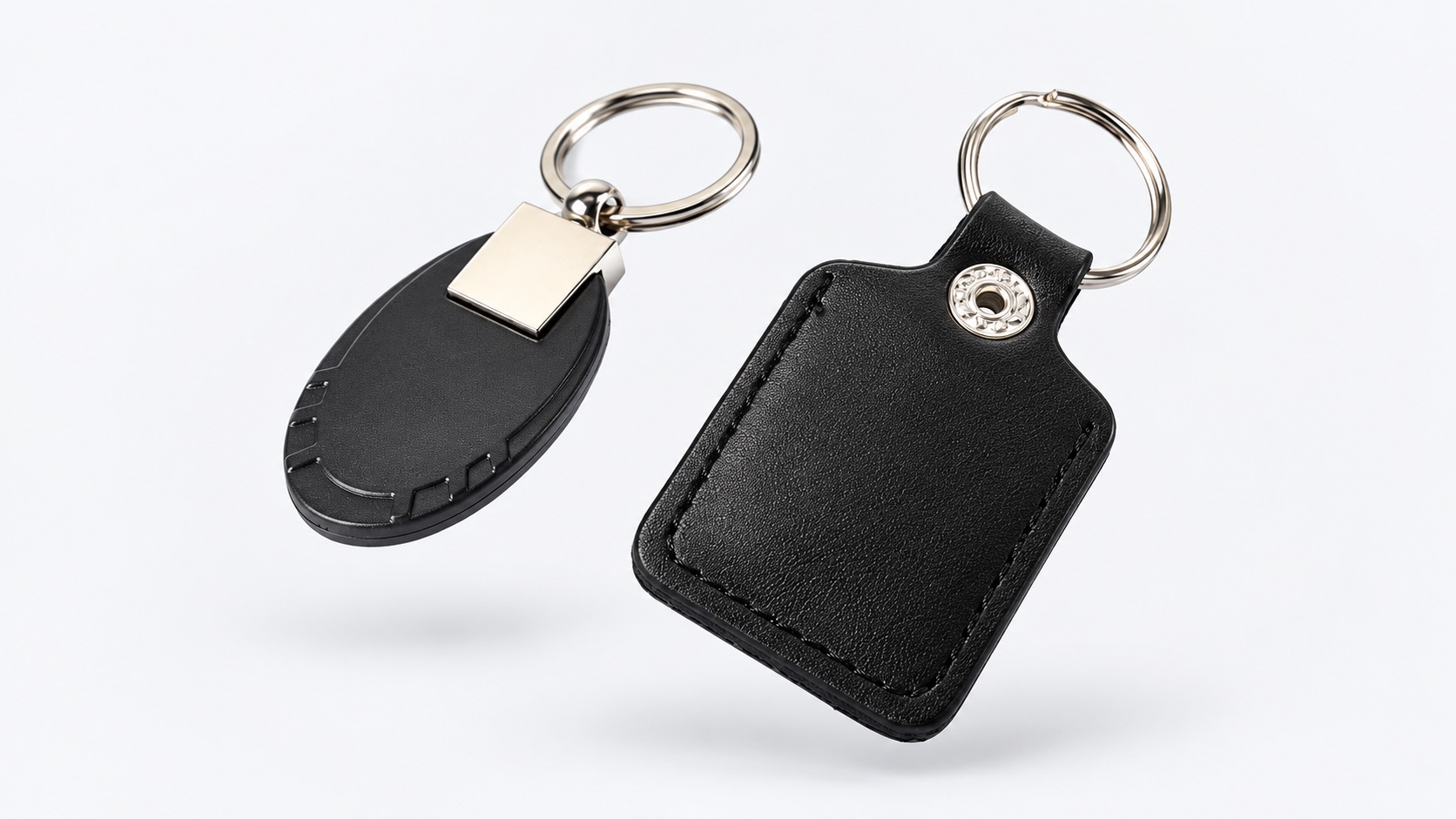 Studio visualization of black PU and metal-trim RFID keyfobs, suspended against a light background.